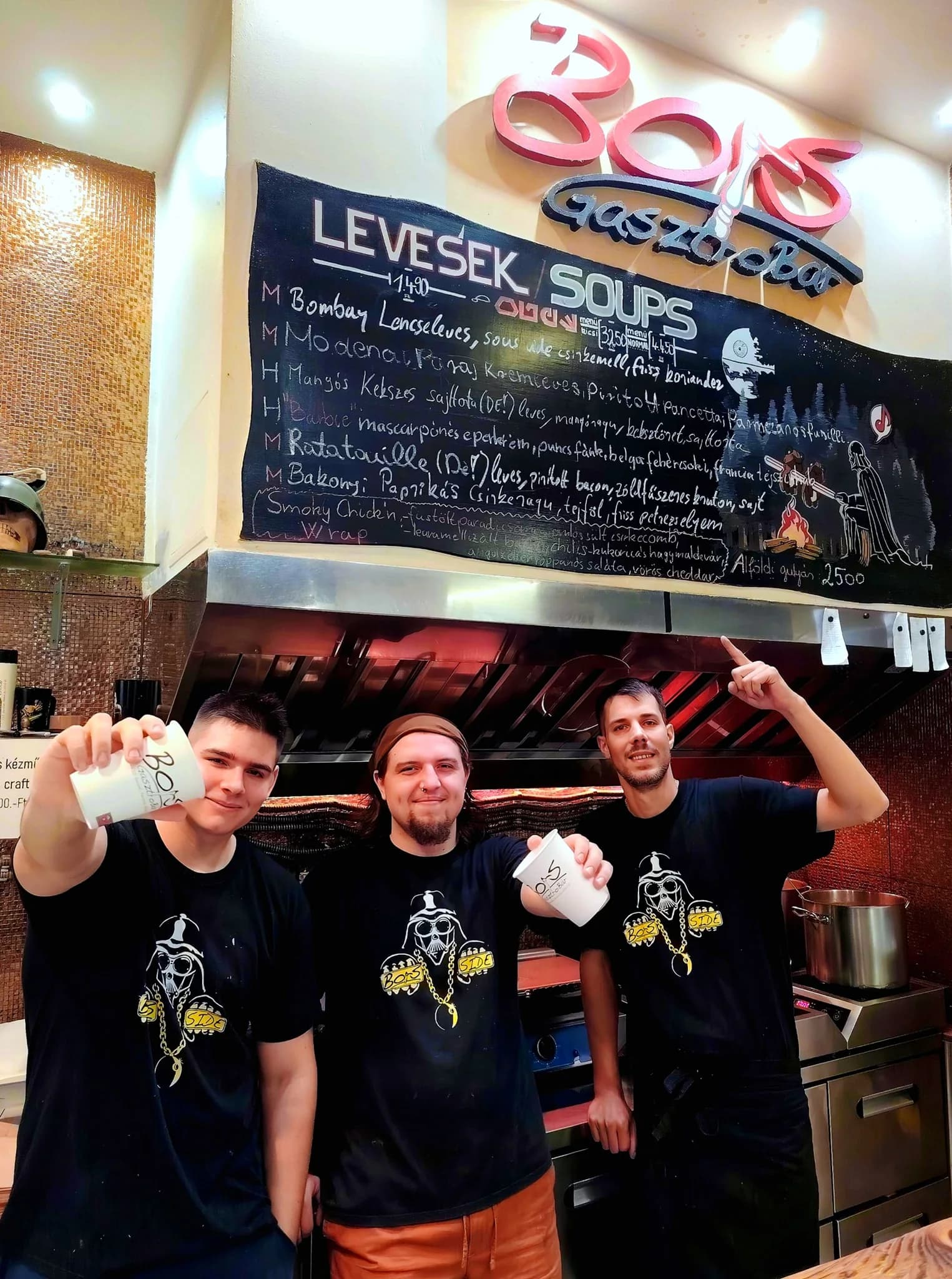 The Bors crew beneath the live handwritten soup board