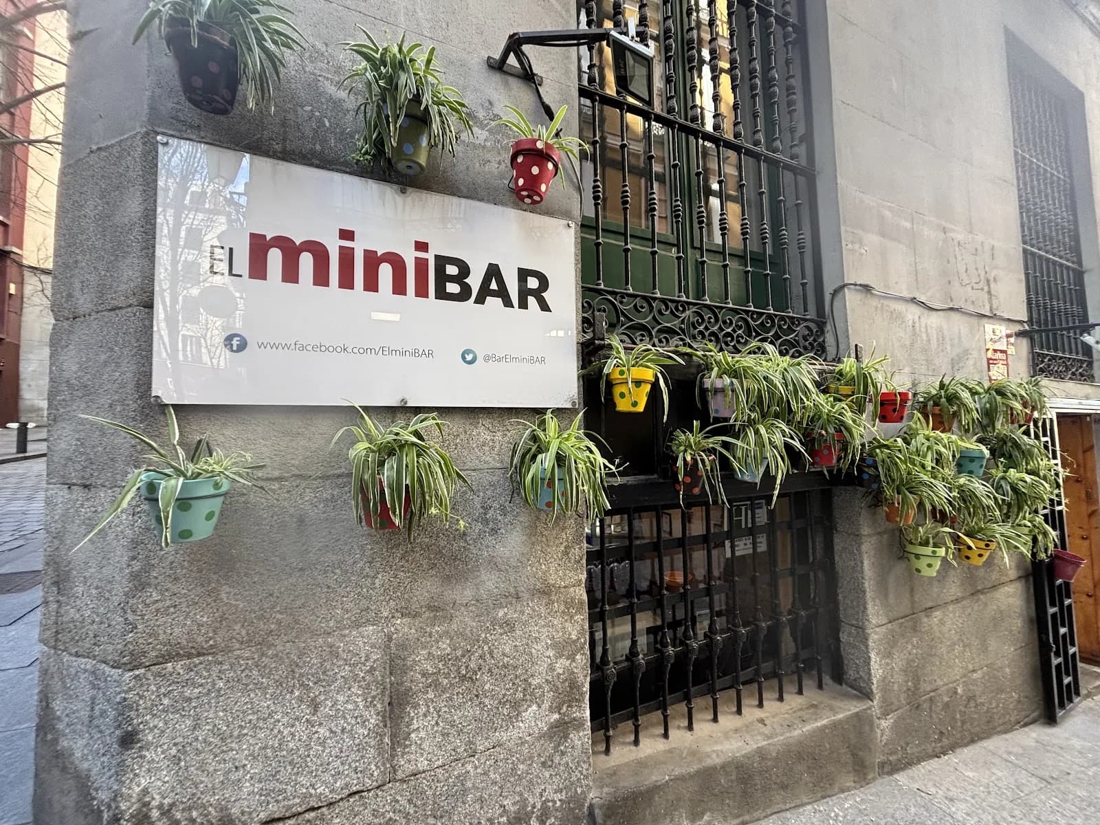 La fachada de El Minibar decorada con macetas de colores