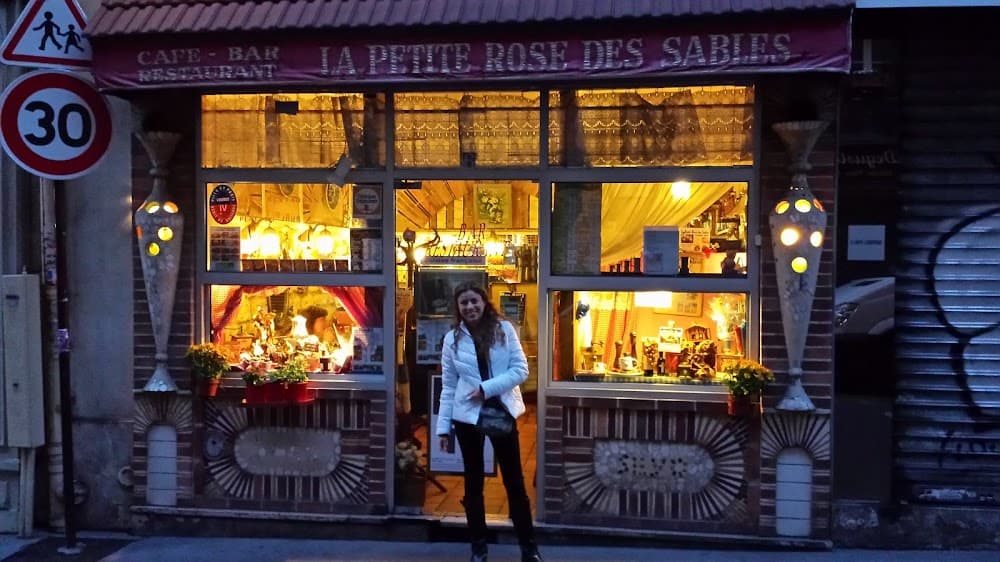 La façade éclairée de La Petite Rose des Sables le soir