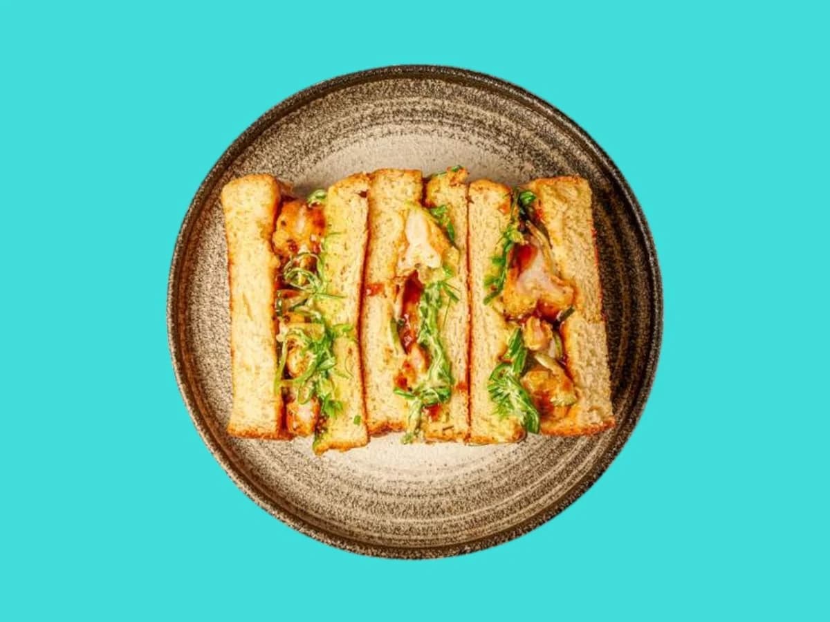 Tuna sando plated against The Sando Shop turquoise background