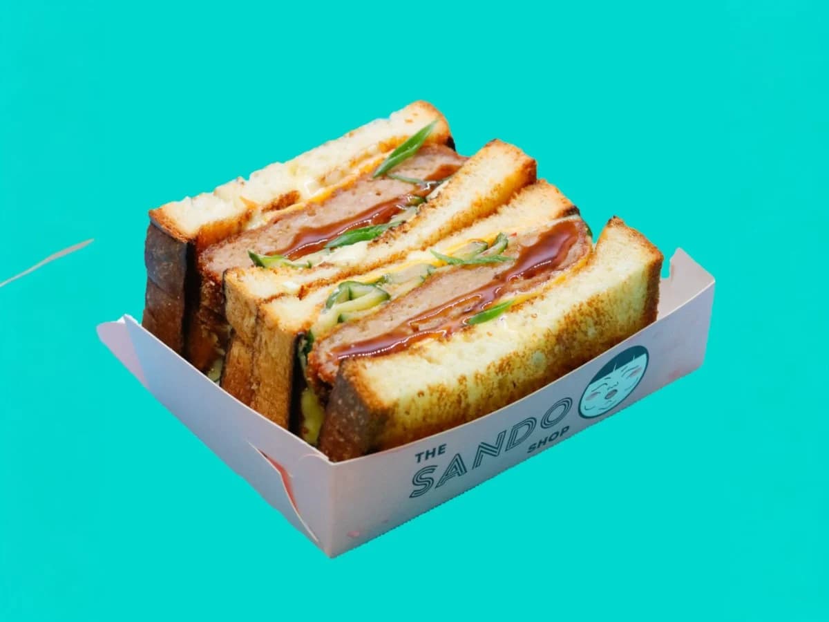Menchi sando plated against a turquoise background