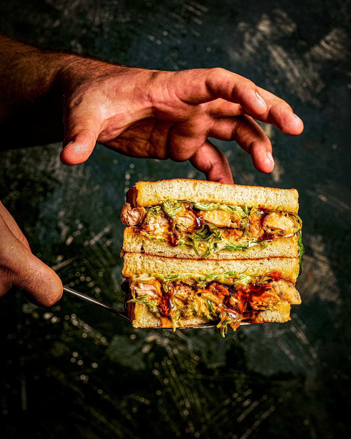 Fish sando photographed against a dark background
