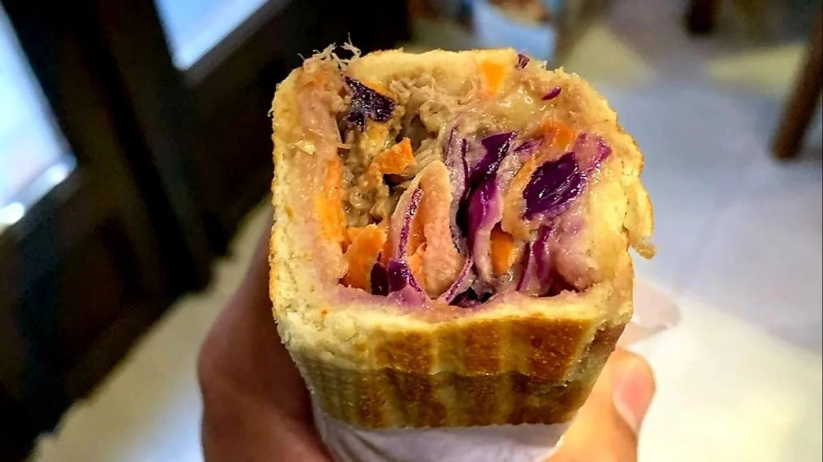 Pulled Pork toasted baguette cut open to show pork and red-cabbage coleslaw
