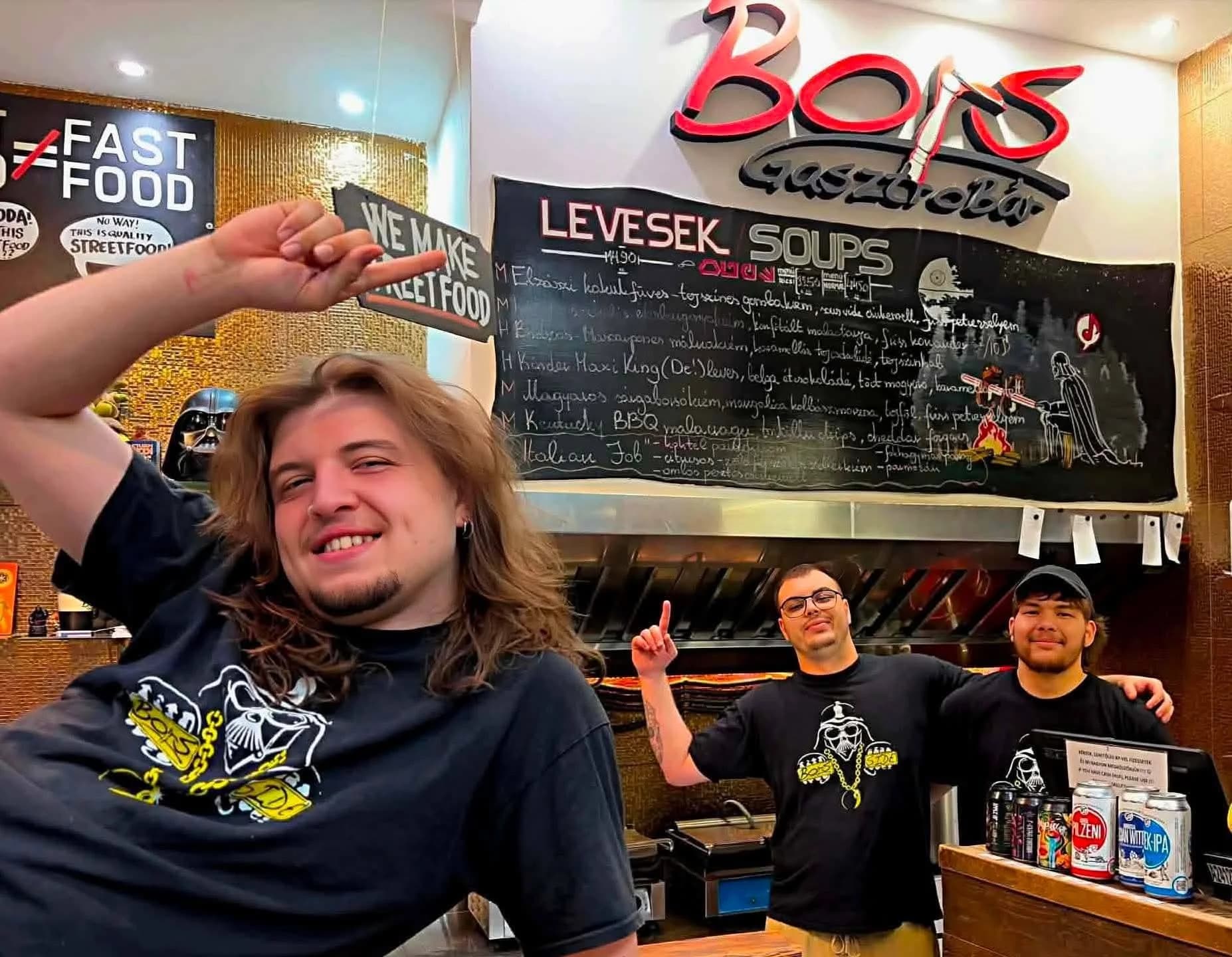 The smiling Bors kitchen crew beneath the daily chalkboard