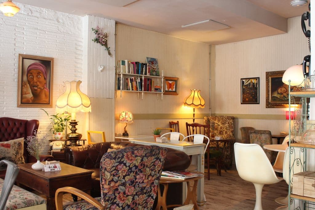 Sala principal del Café de la Luz con butacas, libros y lámparas