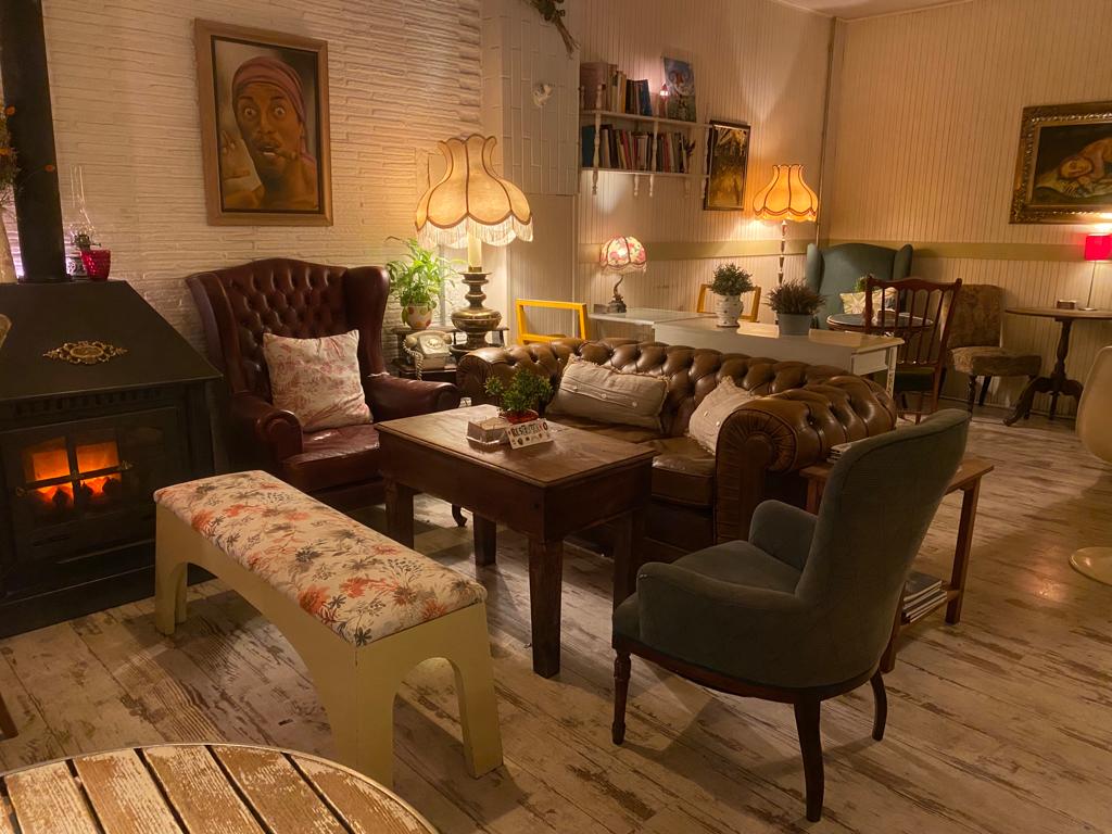 Rincón real de Café de la Luz con chimenea, sofá y butacas