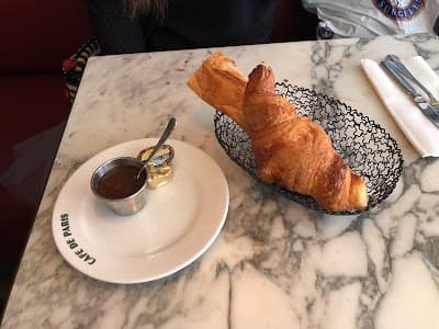 Café et croissant sur une table en marbre