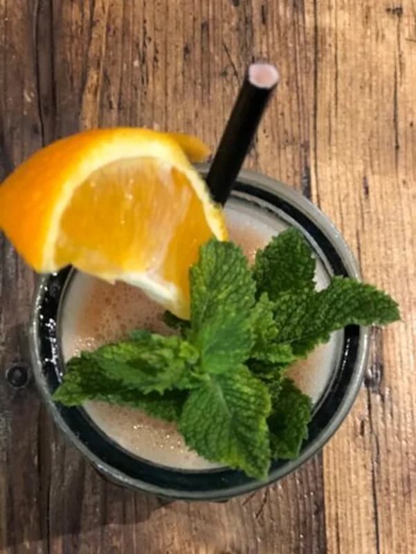 Fresh smoothie garnished with orange and mint