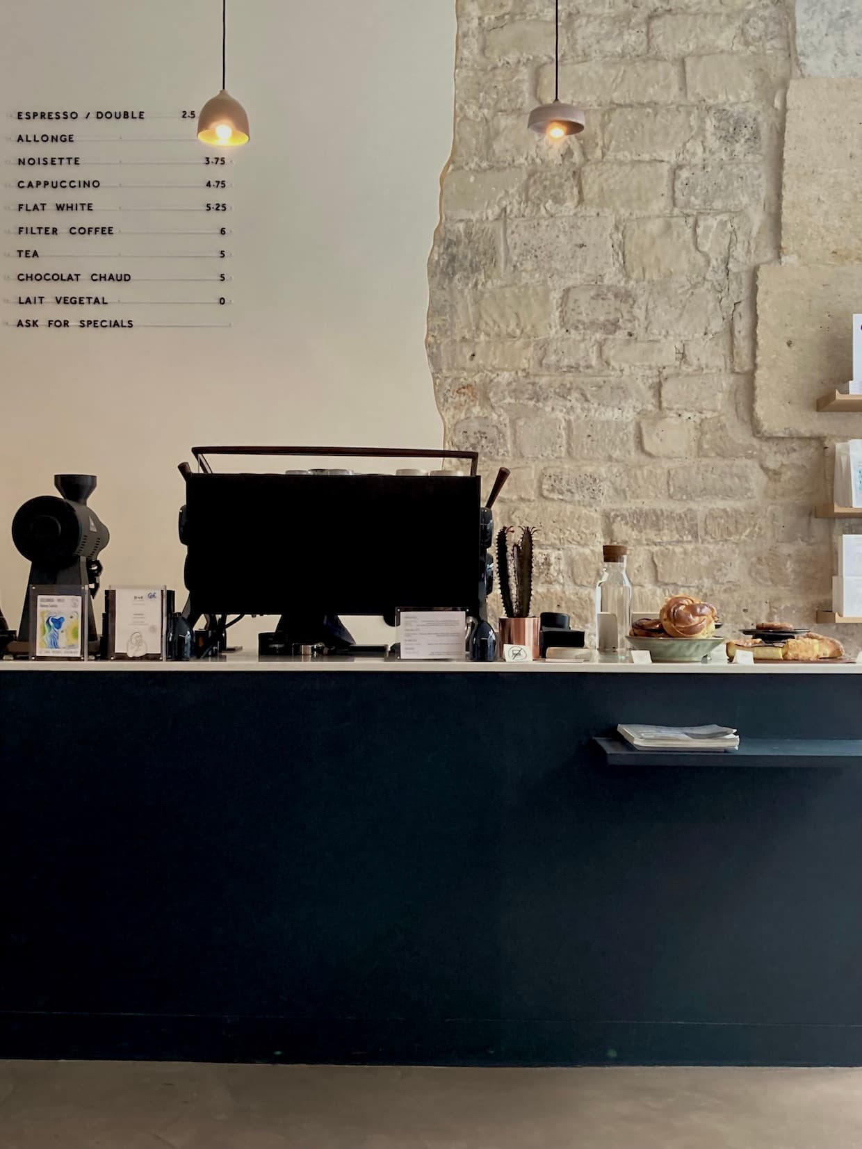 Le comptoir noir, le mur en pierre et les pâtisseries de Clove