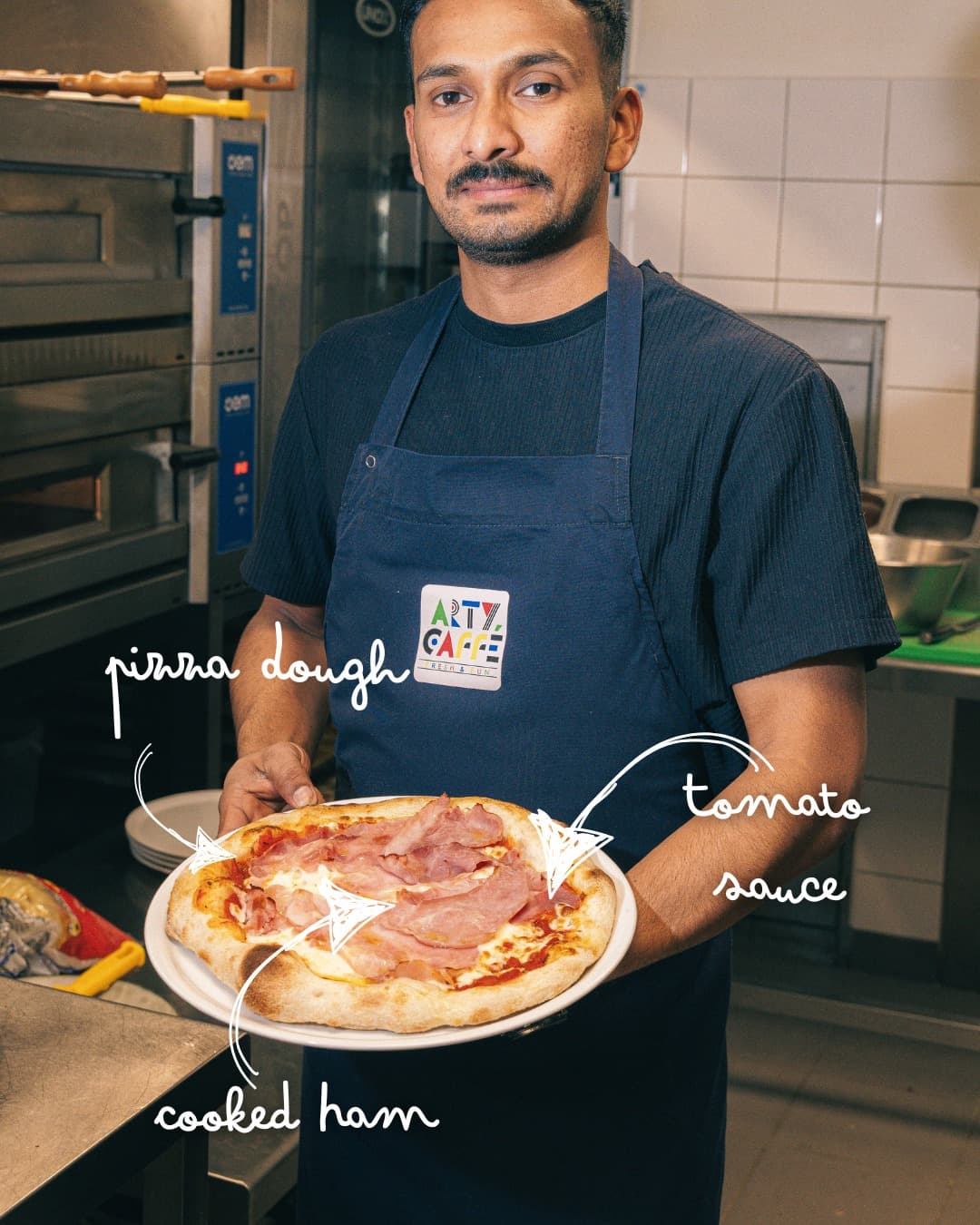 Membre de l’équipe de l’Arty Caffé présentant une pizza