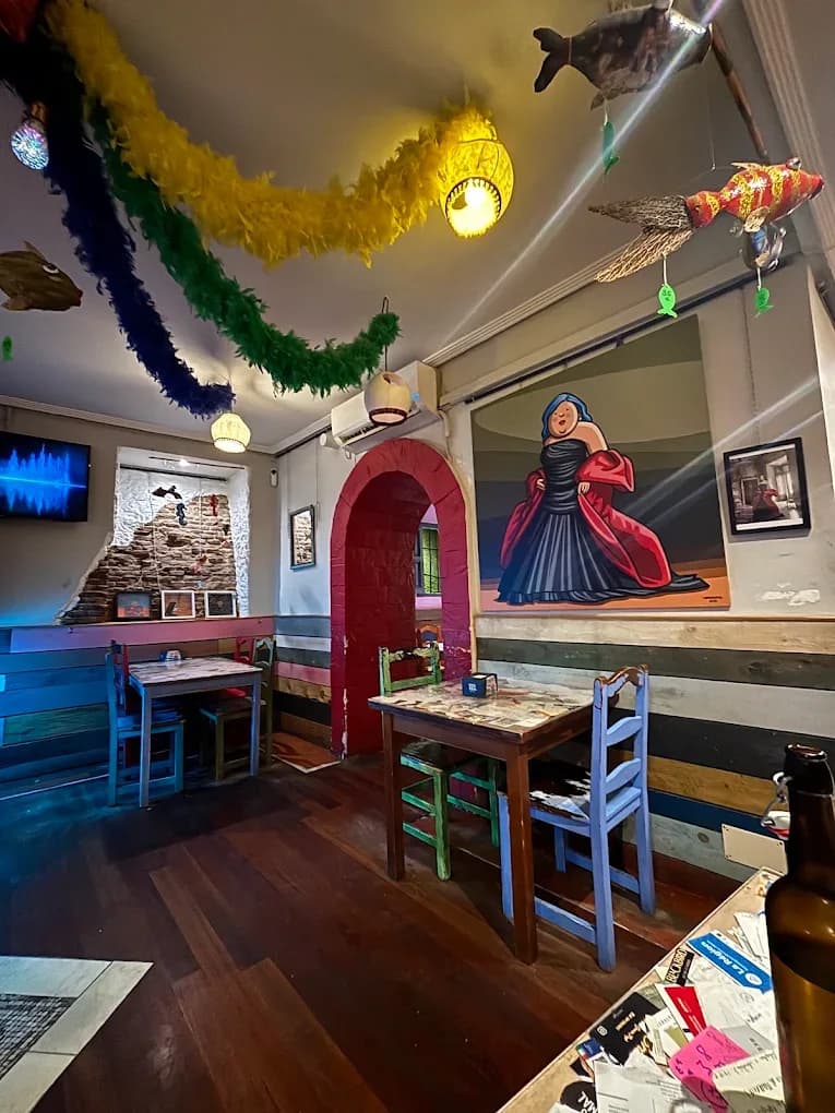 Interior real de El Minibar con sillas de colores, murales y decoración colgante