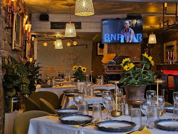 Table dressée avec verres bleus, serviettes jaunes et fleurs