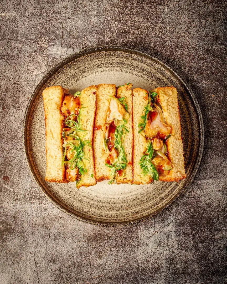 A freshly toasted Sando Shop sandwich on a ceramic plate